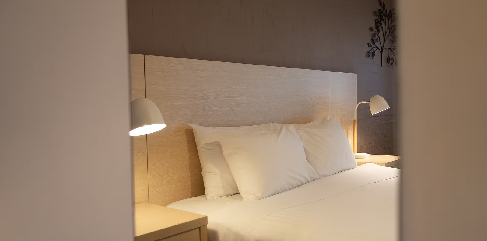 Freshly made bed with bedside lamps